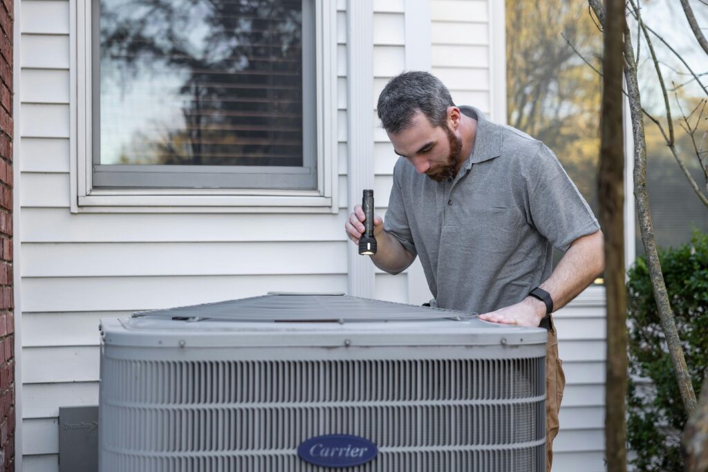 HVAC technician repairing air conditioning unit for Mississippi homeowner. Client received through hvac marketing in mississippi
