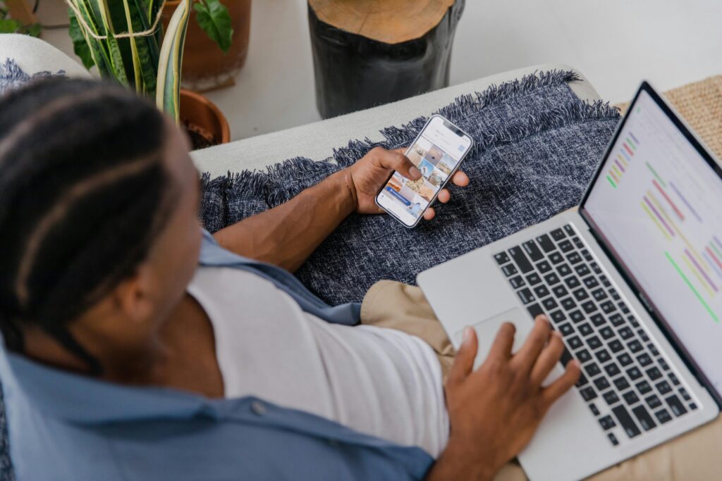 Local business owner comparing google ads vs meta ads on laptop and phone