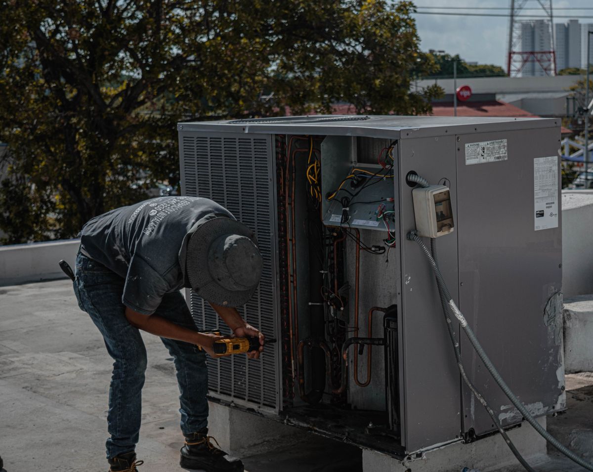 HVAC technician servicing a rooftop air conditioning unit