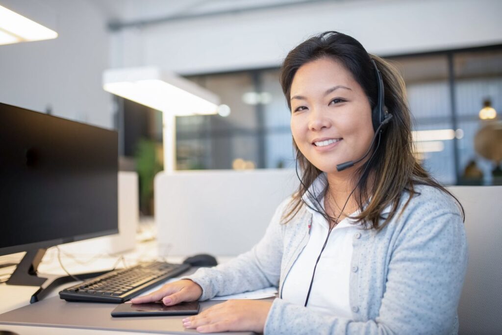 Office team member with a headset answering service calls at a desk