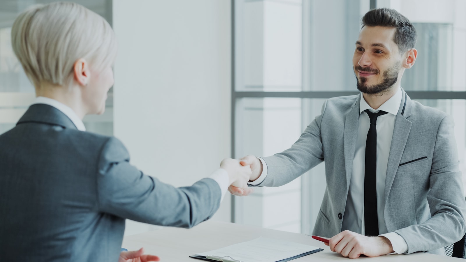Owner shaking hands after working out how to choose a marketing agency that fits the business