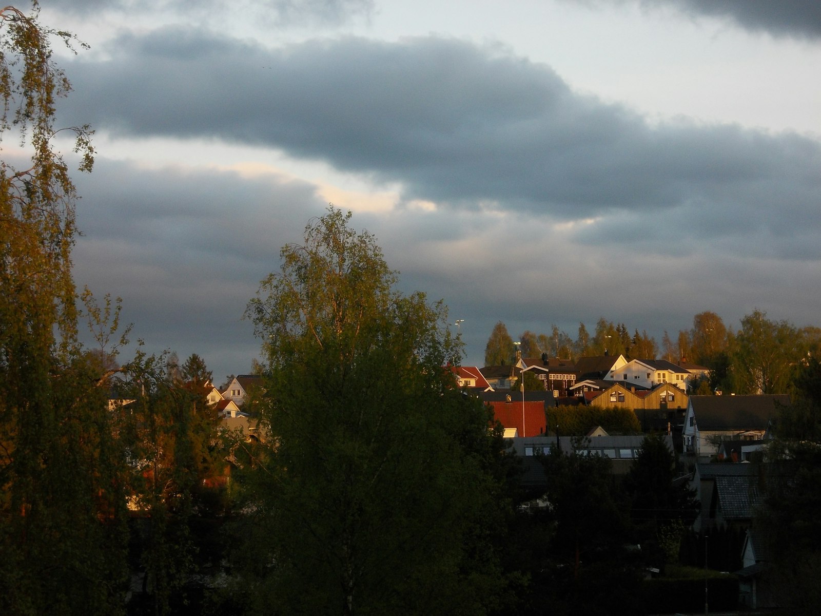 Dark storm clouds rolling over a neighborhood, the moment storm damage marketing for roofers starts earning its keep
