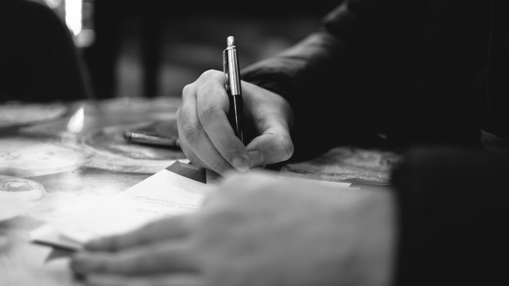 Service business owner drafting ad headlines with a pen and notepad